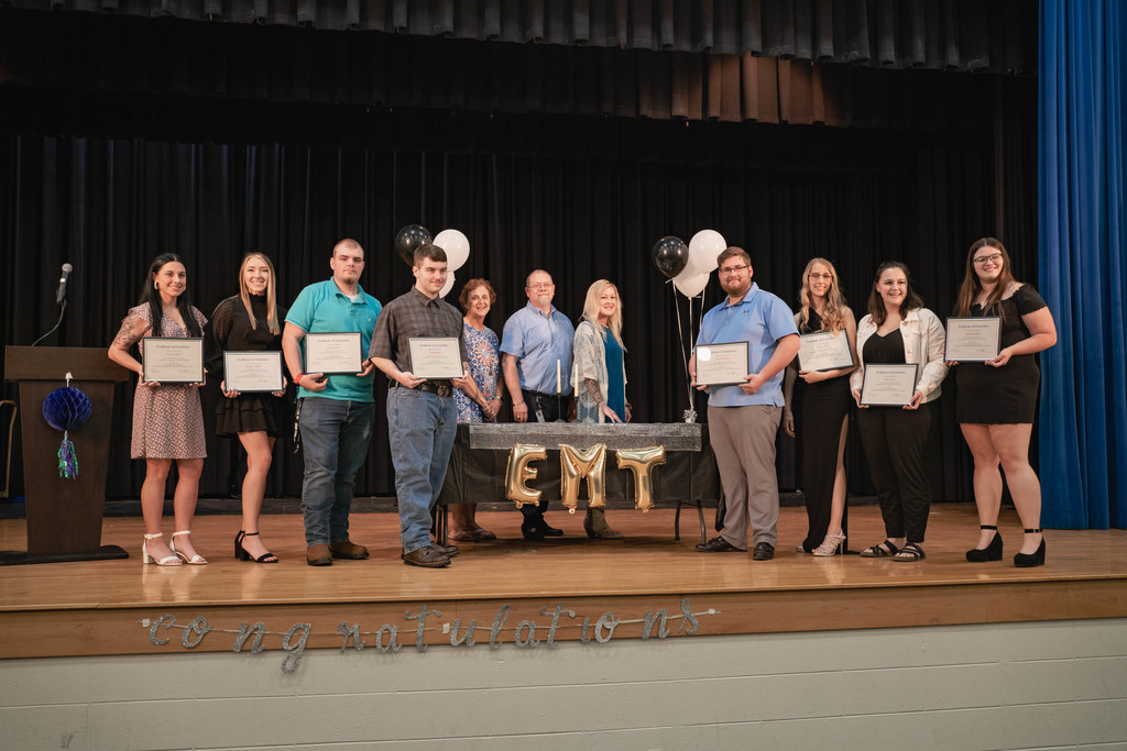 Graduates holding their certificated with instructors